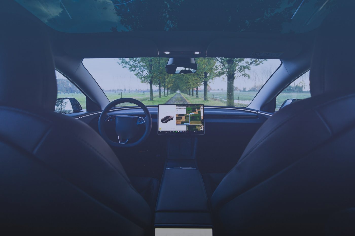 View from the back seat of an electric car toward the center screen, with a NorseLift answer card